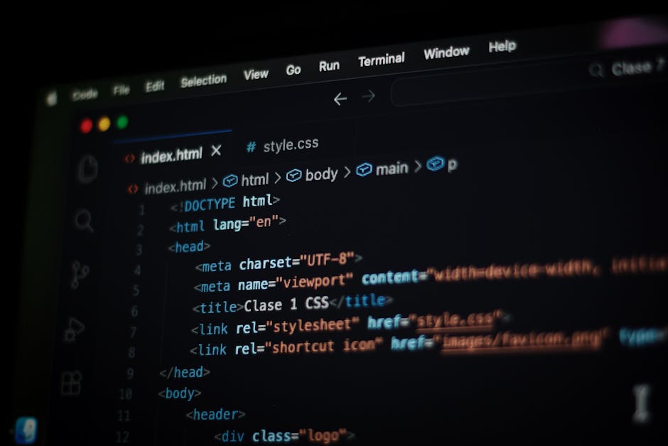 Photograph of a computer screen displaying lines of HTML code in a dark environment, with brightly highlighted syntax in various colors such as green, yellow, and white. The code includes navigation c